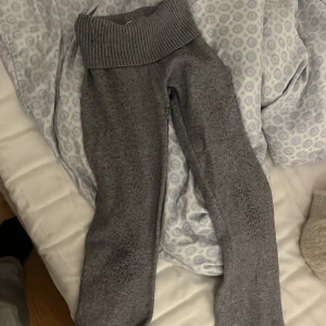 Grå mjukisbyxor från Gina Tricot - Säljer ett par grå mjukisbyxor från Gina Tricot. Byxorna har en bred ribbad midja och är tillverkade i ett mjukt material som ger en bekväm passform. Perfekta för en avslappnad stil.