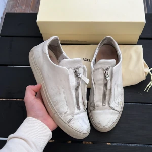Axel arigato clean 90 zip - Säljer dessa vita arigatos. Modell clean 90 zip! Storlek 42 fits 43! Skick 6/10. Kan gå ner i pris vid snabb affär. Hör av dig vid minsts fundering😝