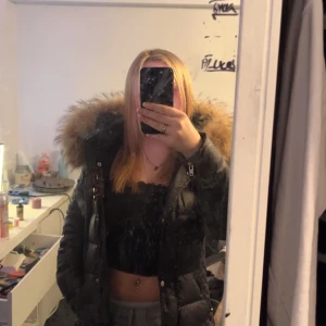 Rock and blue - Säljer en svart dunjacka med stor pälskrage, äkta päls. Jackan har dragkedja och är långärmad, perfekt för kyliga dagar. Den är både stilren och funktionell, vilket gör den till ett måste i garderoben. Passar bra för vintern och hösten.