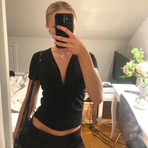 Svart topp - Säljer en jättesöt svart v-ringad topp från BikBok i storlek XS 💗