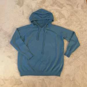 30% Kashmir 70% merinoull hoodie (blå) - Säljer en snygg blå hoodie med långa ärmar och justerbar huva. Perfekt för en avslappnad stil. Den har ribbade muddar vid ärmslut och nederkant för extra komfort. Är en S men passar något mindre. Hör av dig vid funderingar och pris kan diskuteras mvh Malte 
