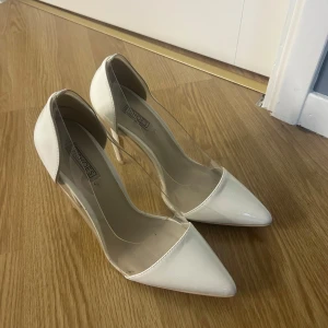 Vita klackar med spetsig tå - Eleganta vita klackskor med spetsig tå och transparenta sidor. Perfekta för en stilren look. Använda en gång.