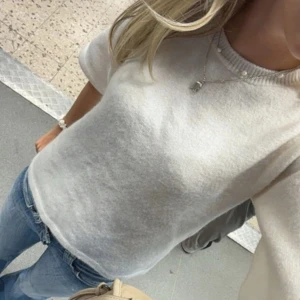 Beige stickad tröja från H&M - Säljer en stilren beige stickad tröja från H&M den sitter likadant som den vita och är exat samma modell fast i beige. Tröjan har korta ärmar och en rund halsringning, perfekt för en avslappnad look. 