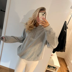 Grå hoodie - Säljer en bekväm och stilren grå hoodie med långa ärmar och en klassisk huva. Perfekt för en avslappnad look. 