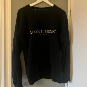 Svart tjocktröja från Acqua Limone - Svart sweatshirt från Acqua Limone med tryck både fram och bak. Tröjan har långa ärmar och är tillverkad i 100% bomull. 