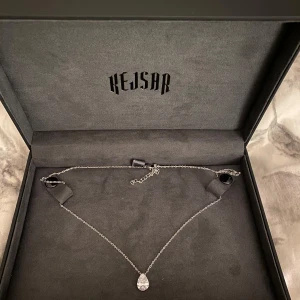 Silverhalsband med droppformad berlock från Kejsar - Elegant silverhalsband från Kejsar med en vacker droppformad berlock. Perfekt för att ge en stilren touch till din outfit. Kommer i en snygg svart förpackning med Kejsar-logga.