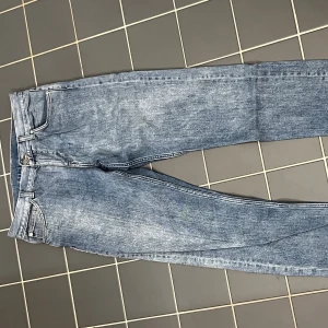 Blå jeans från Weekday - Snygga blå jeans från Weekday med en klassisk straight fit. De har en knappgylf och femficksdesign. STRL 29/32