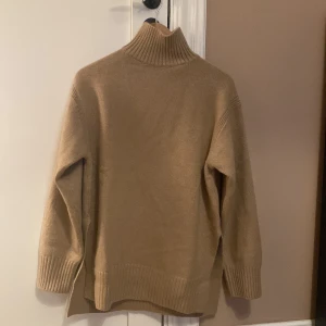 Beige stickad polotröja från H&M - Säljer en beige polotröja från H&M. Nyskick! Endast testad⭐️                                                                          Tröjan har en hög krage och långa ärmar, perfekt för kyligare dagar. Den är tillverkad i ett mjukt material som ger en bekväm passform.
