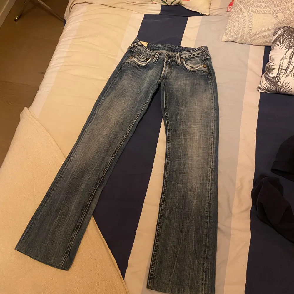 Säljer dessa jättesnygga vintage Jeans från Le Temps Des Cerises!😇 Har aldrig använt dem och är i perfekt skick! De är lågmidjade och bootcut och har superfina detaljer på fickorna. Tveka inte på att höra av dig vid frågor!!💖💖 Midjemått rakt över: 36cm Innerbenslängd: 74cm Ytterbenslängd: 92cm. Farkut & Housut.