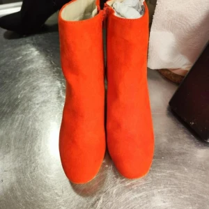 Red mocka boots - Snygga orange boots i mocka med dragkedja på sidan. Perfekta för att liva upp din outfit med en färgklick.