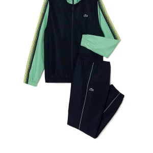 Navu blue  och grön  tracksuit från Lacoste - Snygg tracksuit från Lacoste i navy blueoch grönt med dragkedja och huva. Tracksuit är med ett coolt mönster i gult och grönt längs sidorna. Ny pris är 2700 i hedeoutlet och priset kan absolut diskuteras 