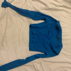 Blå ribbad tröja från Zara - Säljer en snygg blå ribbad tröja från Zara. Tröjan har en stilren design med långa ärmar och en krage. Perfekt för en trendig look! Använd en gång, fel storlek! 