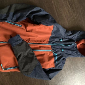 Vinterjacka från O'Neill - Säljer en cool orange och mörkblå jacka från O'Neill med dragkedja och huva. Jackan har en blå insida och flera praktiska fickor med dragkedjor. Perfekt för kyliga dagar med sin Thinsulate-isolering. Skidjacka/vinterjacka