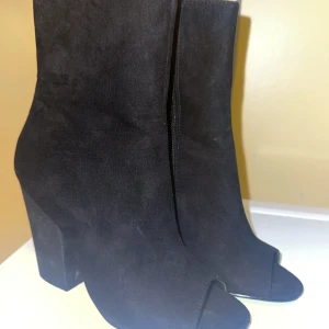 Svarta boots från NA-KD - Snygga svarta boots från NA-KD i mocka med öppen tå och hög klack. Perfekta för en trendig look.