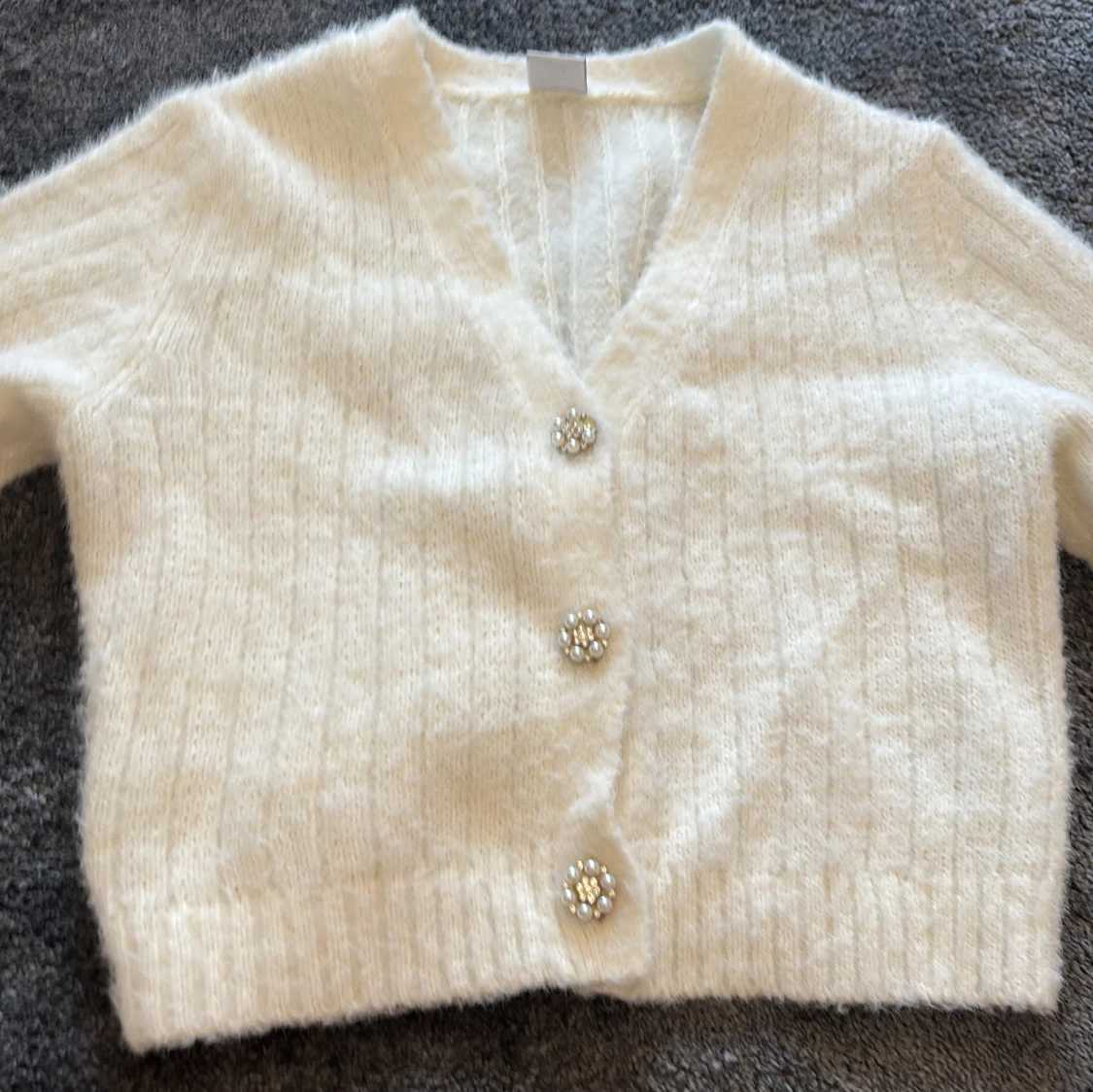 Vit kofta med pärlknappar