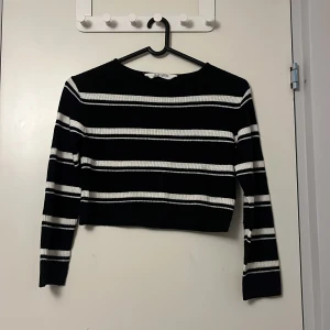 Svart och vit randig tröja från H&M - Säljer en svart och vit randig tröja från H&M. Tröjan är croppad och har långa ärmar. Perfekt för en stilren look. 🖤🤍