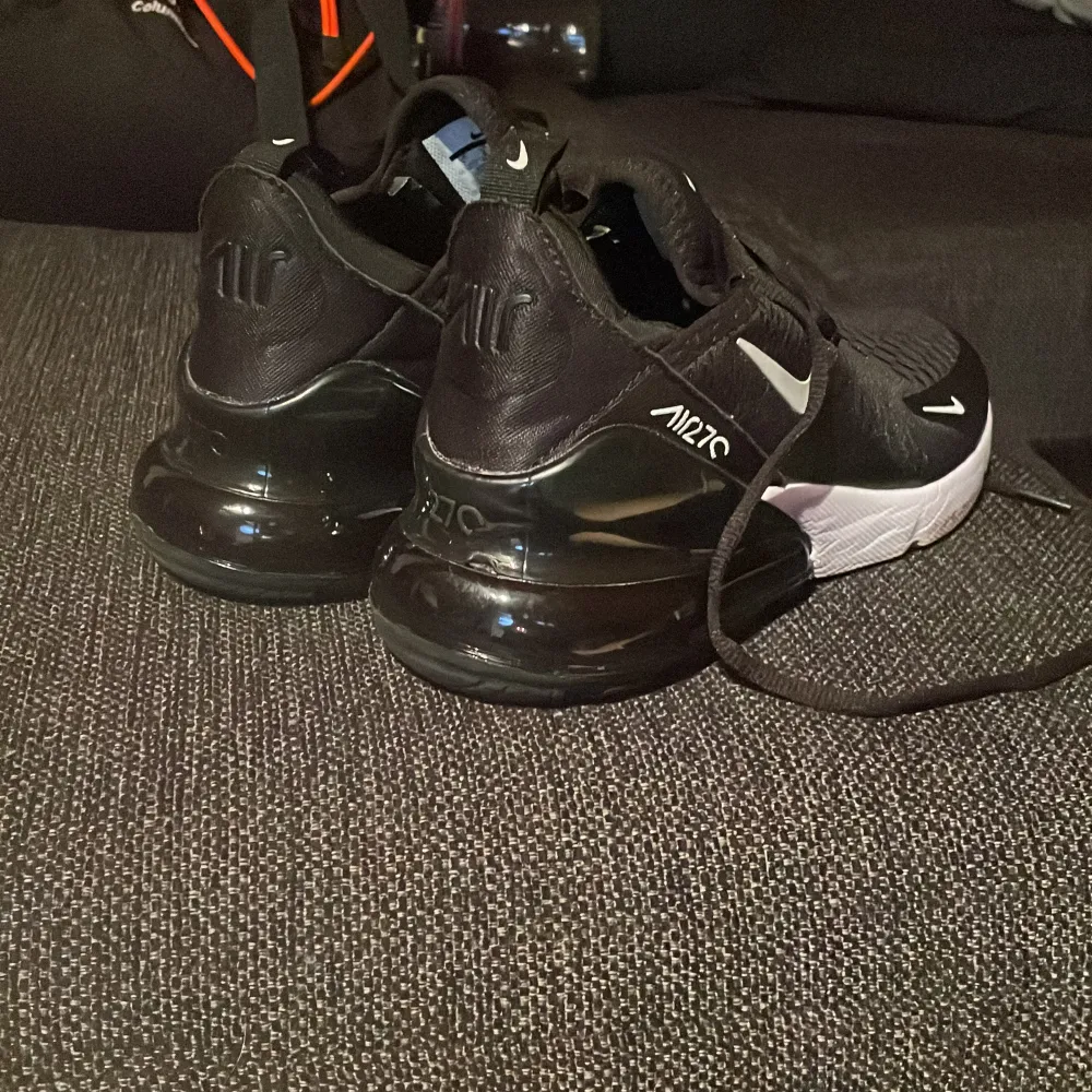 Säljer ett par svarta Nike Air 270 sneakers med vit sula. Skorna har snörning och en luftig design för extra komfort. Perfekta för både träning och vardag.. Kengät.