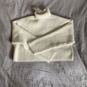 Vit polotröja - Säljer en stilren vit ribbad polotröja med långa ärmar. Perfekt för kyligare dagar och lätt att matcha med olika outfits. Tröjan har en klassisk design med en hög krage som ger extra värme. Köptes för 350 på hm, har aldrig använt och prislappen är kvar.  Bara att fråga för fler bilder. 