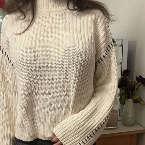 Stickad tröja med detaljer  - Säljer denna super söta vita stickade tröja med unika svarta sömdetaljer💕 för bara 250!