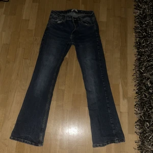 Mörkblå bootcut jeans - Snygga mörkblå bootcut jeans med klassisk femficksdesign. Perfekta för en avslappnad stil med en touch av retro. Passar bra till både sneakers och klackar.