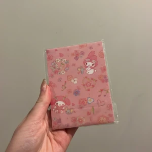 Rosa anteckningsblock med My Melody-motiv - Sött rosa anteckningsblock dekorerat med My Melody-karaktärer och blommor. Perfekt för att skriva ner dina tankar eller som en fin present till en vän. Kompakt och lätt att bära med sig.