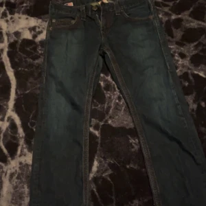 Mörkblå jeans från True Religion - Säljer ett par mörkblå jeans från True Religion. De har en klassisk femficksdesign och är tillverkade i USA. Perfekt för tjejer och killar