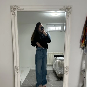 Blå jeans med hög midja - Snygga blå jeans med mid weist och en avslappnad wide fit. Perfekta för en trendig och bekväm stil. Passar bra till olika outfits och tillfällen.