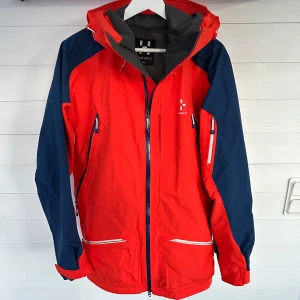 Haglöf Goretex Skidjacka - Haglöf Chute II Skaljacka  Stor i storleken, passar både large och medium. Nypris: 4200kr Beskrivning: Fullt utrustad freeride-jacka. Tillverkad i tvålagers GORE-TEX®, helt vind- och vattentät med hjälmkompatibel huva och enkel åtkomst till fickor, även med ryggsäck. Sparsamt använd. Färg mest lik första bild. ❗️Tre små knappt synliga märken på rygg se sista bild, går nog bort om man testar tvätt.