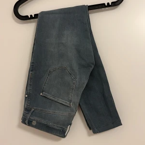 Blå jeans från River Island - Snygga blå jeans från River Island med klassisk design. De har en normal passform och är perfekta för en avslappnad stil. Jeansen har en praktisk bakficka och är tillverkade i ett slitstarkt material.