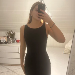 Svart maxi dress från Gina tricot  - Snygg svart ärmlös klänning med en tight passform. Perfekt för en stilren look. Klänningen är enkel och elegant, vilket gör den lätt att matcha med olika accessoarer. Passar bra i längden på mig som är 177, perfekt nu till jul att ha en kofta eller stickad tröja över! Är i storlek xs men väldigt stretchig!💗