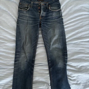 Blåa nudiejeans - Ett par riktigt fräscha och stilrena nudie jeans i storlek 31/34. Jeansen har väldigt feta slitningar på framsidan och bakfickorna som tar byxorna till en ny nivå! Hör av er vid intresse!
