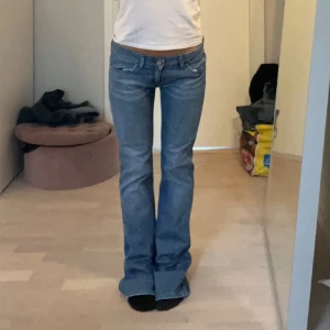 Blå bootcut jeans - Lågmidjade bootcut jeans från Wrangler. Midjemått:39 cm rakt över. Innerbenslängd: 84 cm💗