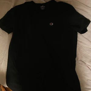 Svart t-shirt från Champion - Säljer en klassisk svart t-shirt från Champion med deras logga på bröstet. Storlek M i fint skick 