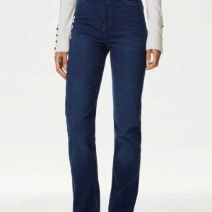 Mörkblå  jeans - Snygga mörkblå jeans med låg midja. Perfekta för en stilren look, dessa jeans har en klassisk design med fyra fickor och knappgylf.