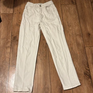 Vita jeans med normal passform - Snygga vita jeans med normal passform och klassisk design. De har en knapp och dragkedja framtill samt fem fickor. Perfekta för en stilren look.