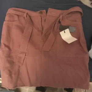 Rosa kjol från ONLY - Snygg rosa kjol från ONLY med knytband i midjan och praktiska fickor. Perfekt för en avslappnad stil. Kjolen har en klassisk design som passar till många olika tillfällen. Nypris 359