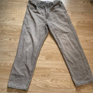 Grå byxor från Jack & Jones - Säljer ett par grå ”relaxed chris” byxor från Jack & Jones. De har en loose passform och är tillverkade i ett bekvämt material. Perfekta för en avslappnad stil.