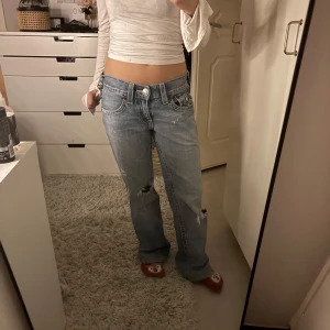 Blå jeans från True Religion - Säljer ett par blå jeans från True Religion med snygga slitningar och klassisk femficksdesign. Jeansen har låg midja och är bootcut. För stora för mig så de är därför jag säljer dom. Köpta begagnat. Kan visa bild på tjejen som jag köpte dom från om man vill se bättre passform❣️