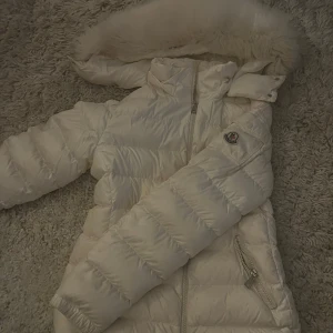 Vit molly med päls MONCLER - Vit jacka med päls från moncler, köpt på NK förra året. Köptes för 12000 men kommer sälja den ganska mycket billigare eftersom lappen som brukar sitt i hörnet på jackan ramlade av när jag kemtvättade den! Storlek 1💗