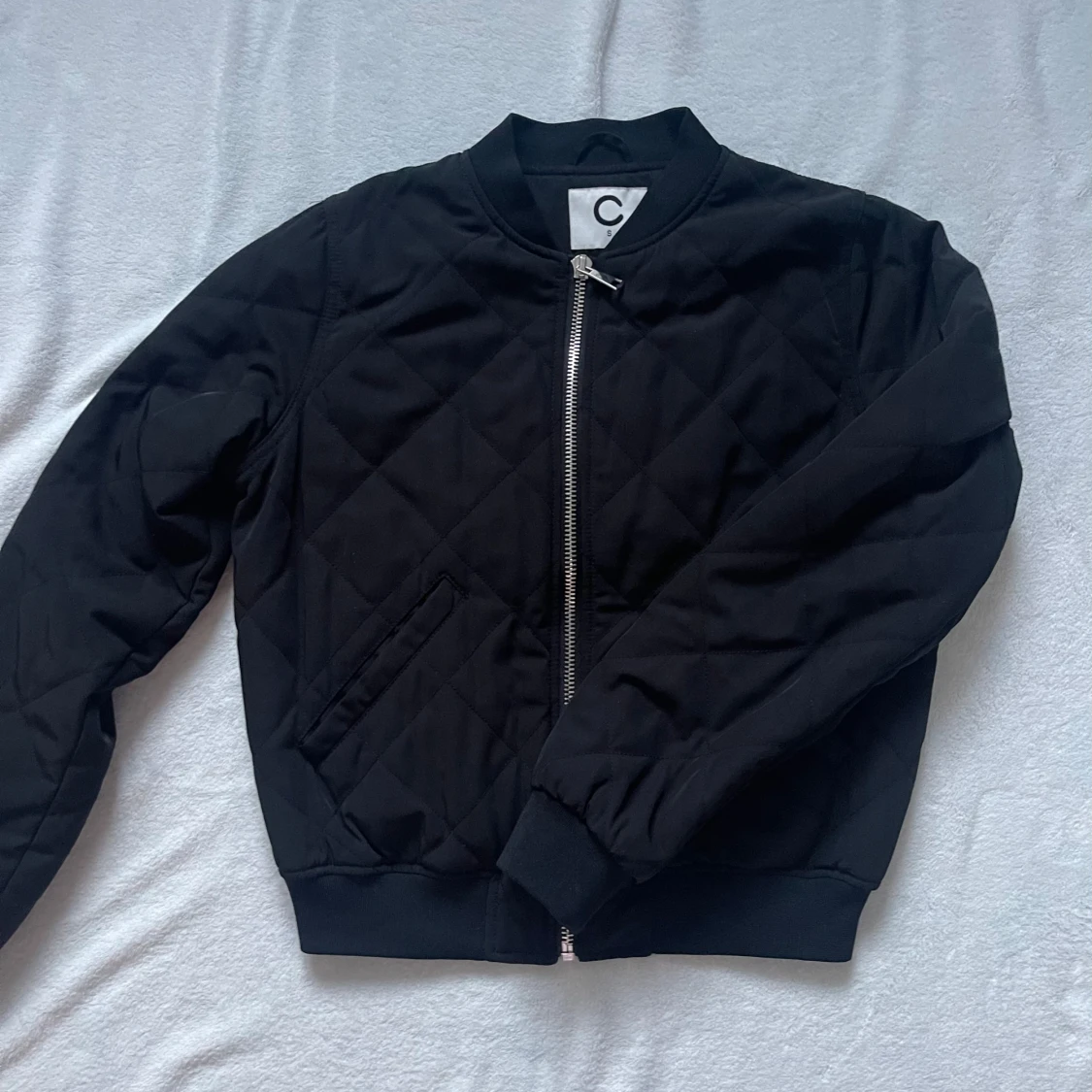 Svart quiltad bomberjacka