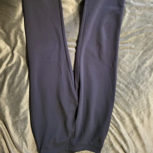 Mörkblå kostym/mjukisbyxor - Säljer ett par mörkblå kostym/mjukisbyxor med elastisk midja. Byxorna har en loose passform och är perfekta för en avslappnad stil. De är tillverkade i ett mjukt material som ger hög komfort.