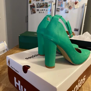 Gröna pumps  - Snygga gröna pumps  med spetsig tå och klack. Skorna har en elegant design med en justerbar rem runt ankeln för extra komfort och stil. Perfekta för att ge en färgklick till din outfit.Helt nya Eu 39