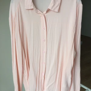 Ljusrosa knytblus från Gina Tricot - Säljer en ljusrosa blus från Gina Tricot som knyts nertill. Blusen har långa ärmar och en klassisk krage. Perfekt för en stilren look. Blusen är i mycket fint skick🌸