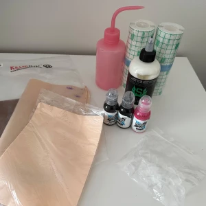 Tatueringstillbehör - Litet kit med saker jag inte längre behöver. -3st fakehud (2st är av märket reelskin) -2st tatueringsplast (klisterplast) -3st bläck från ”worlds famous ink”, 2st svarta, 1st rosa. -1st nästan full stencil stuff -1st sprutflaska  -bläckkoppar