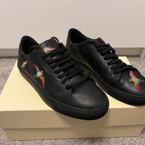 Säljer nu mina Arigatos de är i mycket bra skick förutom att dom har en liten repa på sidan som man kan se på bild 5 - Svarta arigatos med fåglar på