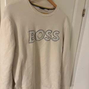 Hugo boss sweatshirt - En stilig Hugo boss tröja i färgen beige.  Använd  1/ Max 2 gånger.  Storlek L.
