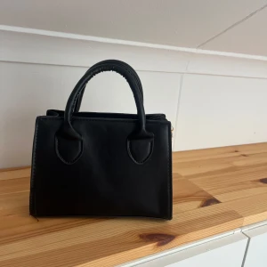 Väska - Svart liten handväska med tillkommande axelband 