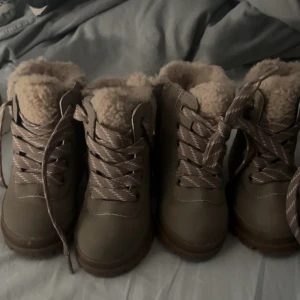Kängor - Säljer ett par snygga och varma kängor från H&M i beige färg. De har en robust sula med bra grepp och är fodrade med mjukt material för extra värme. Perfekta för höst och vinter! Skorna är i storlek EU 20/21. 1 par = 50kr, 2 par = 90