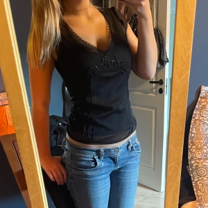 Svart mesh topp  - Svart meshtopp med spets och paljetter. Har ett vanligt svart linne under på bilden. Finns inga defekter och den är i storlek S ifrån Lindex 