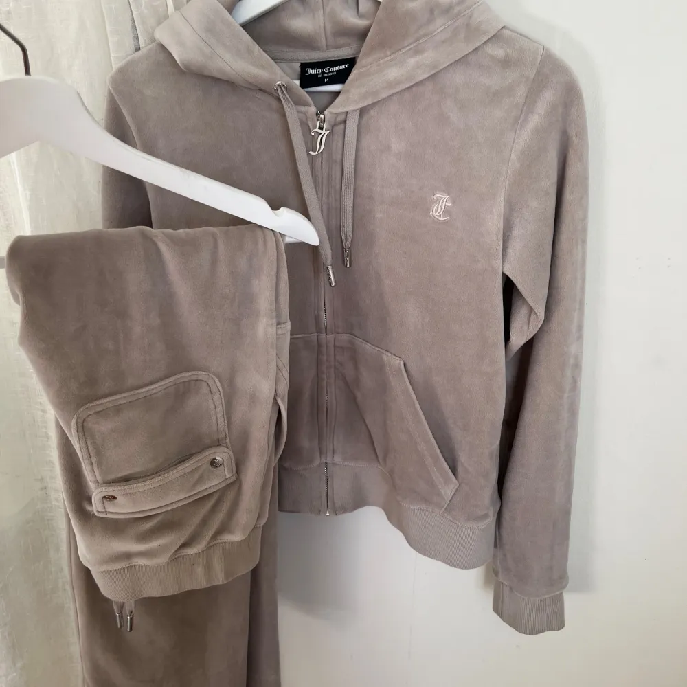 Färgen heter ”string” och är kall beige. Skräddare har stytt upp byxorna 6cm då dom var för långa. Jag är 163 och har ganska korta ben. Byxa är XS och tröja M. Byxor stora i storleken! tröjan liten i storlek. Använts settet endast 2-3 gånger 🫶🏼☺️. Hupparit & Collegepaidat.